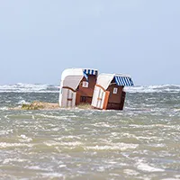 Strandkörbe vom Wasser einer Sturmflut eingeschlassen